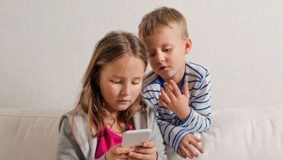 Två barn som tittar på mobil